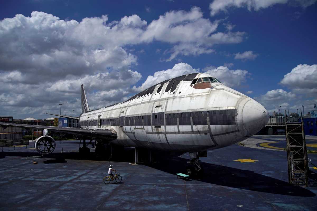FILE PHOTO: A boy rides a bicycle next to retired Boeing 747 airplane on display at Shanghai Expo area, in Shanghai