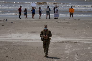 Policeman walks away from residents protesting closed beaches on 4th of July amid the global outbreak of the coronavirus disease in Galveston, Texas