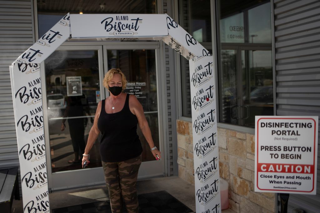 Local resident walks through disinfection station before entering restaurant amid global outbreak of coronavirus disease in San Antonio