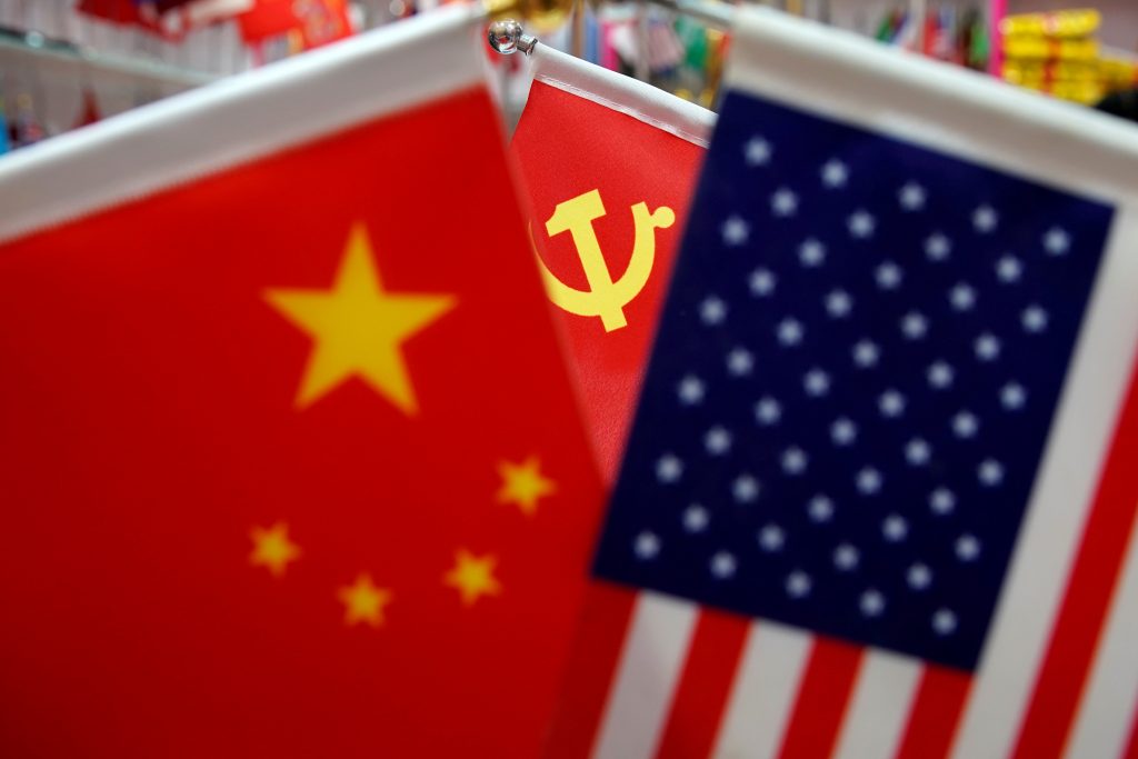 FILE PHOTO: The flags of China, U.S. and the Chinese Communist Party are displayed in a flag stall at the Yiwu Wholesale Market in Yiwu