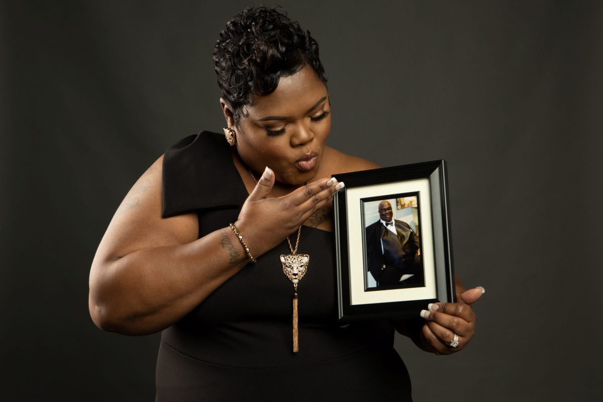A handout image shows Devon Brumfield holding a photo of her father