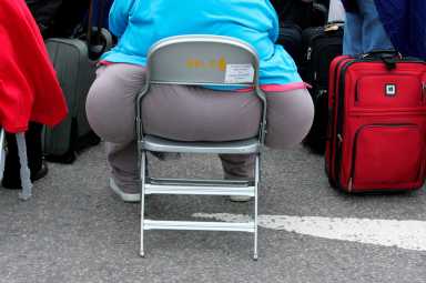 FILE PHOTO: A passenger waits for a delayed flight at Heathrow airport’s terminal four in London
