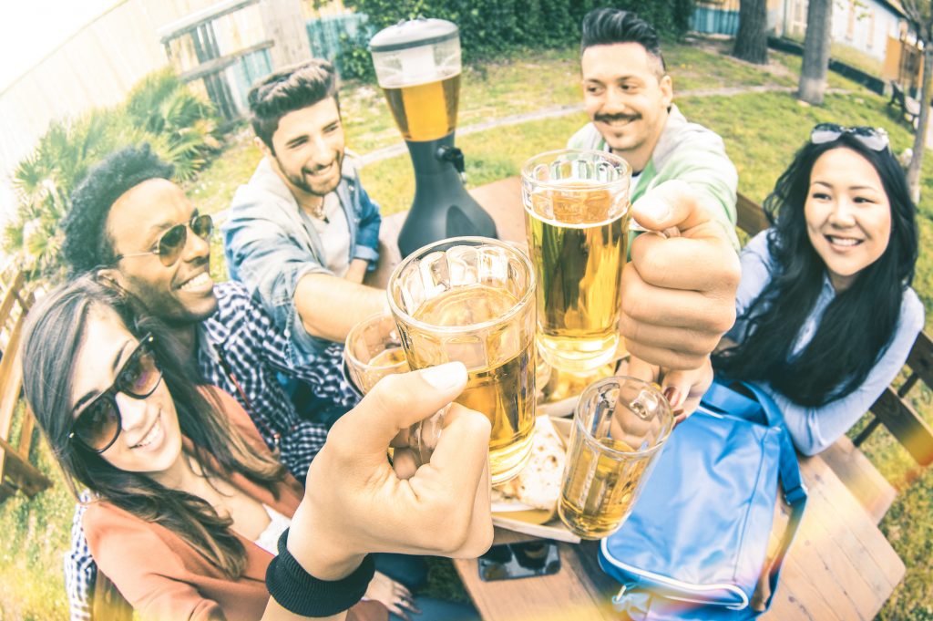 Multiracial group of happy friends millennials eating and toasting beer at garden barbecue party – Multiethnic hangout concept with young people enjoying picnic time together – Warm vintage filter