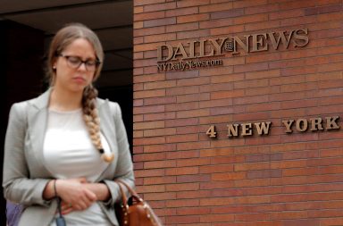 A woman exits the building that houses offices of the New York Daily News newspaper in New York City