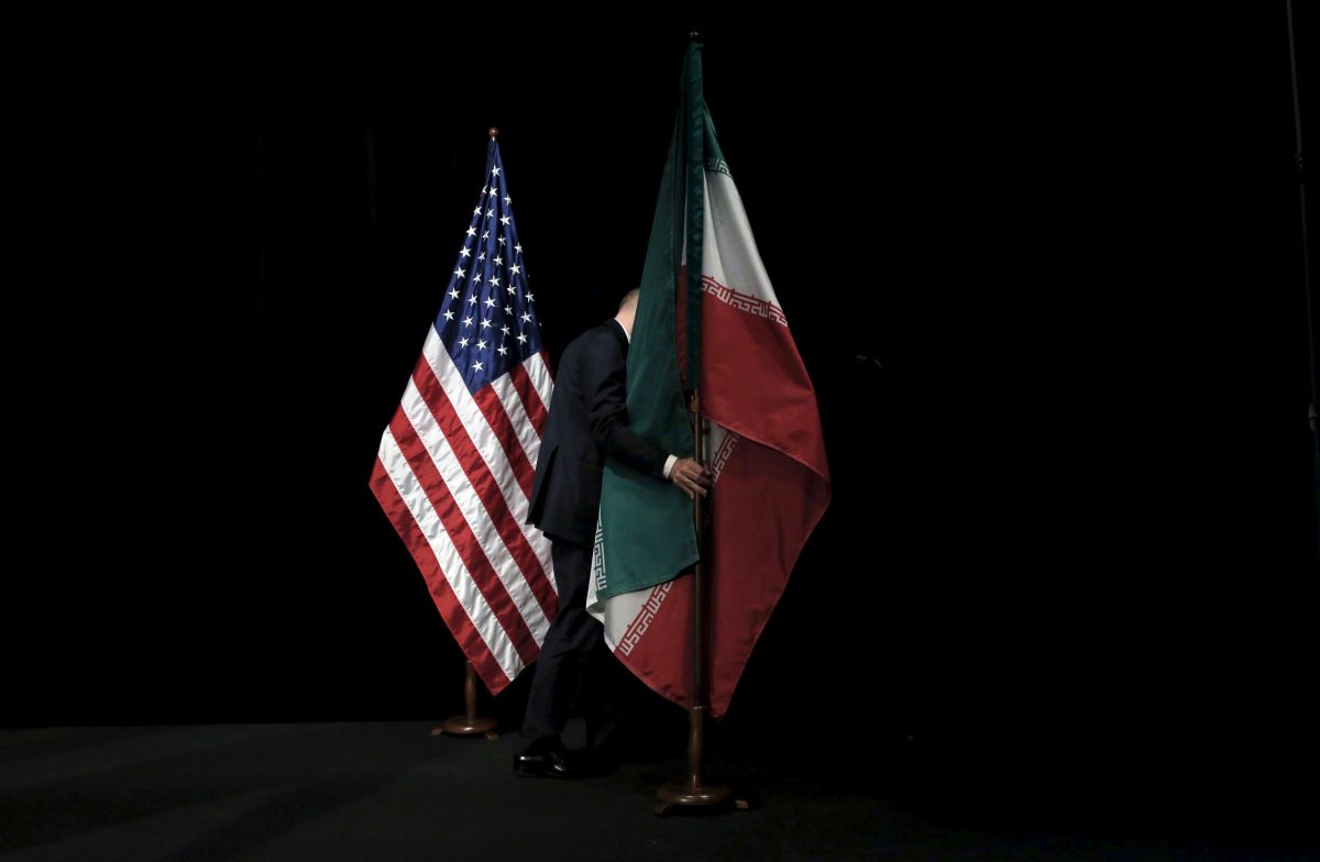 FILE PHOTO:  A staff member removes the Iranian flag from the stage after a group picture with foreign ministers and representatives during the Iran nuclear talks at the Vienna International Center in Vienna