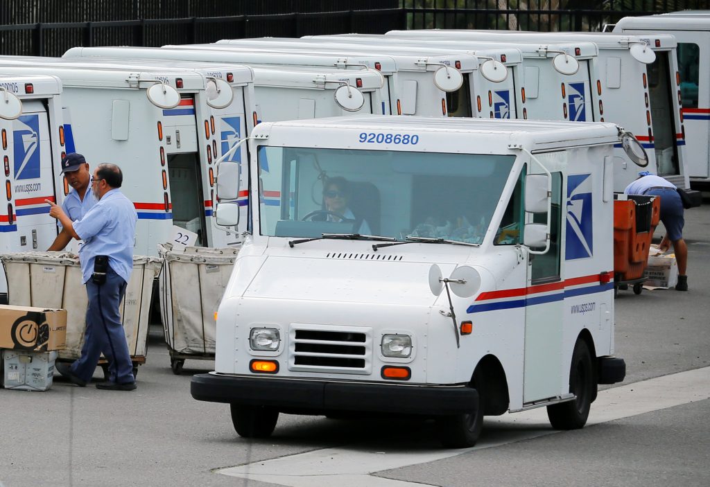FILE PHOTO: U.S. postal workers load their trucks with mail for delivery from their postal station in Carlsbad