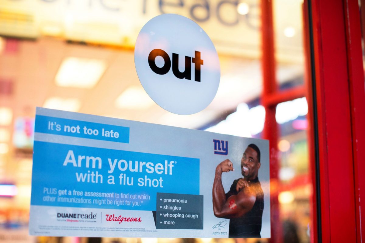 FILE PHOTO: A sign advertising the availability of flu shots is taped onto a door of a Duane Reade in New York