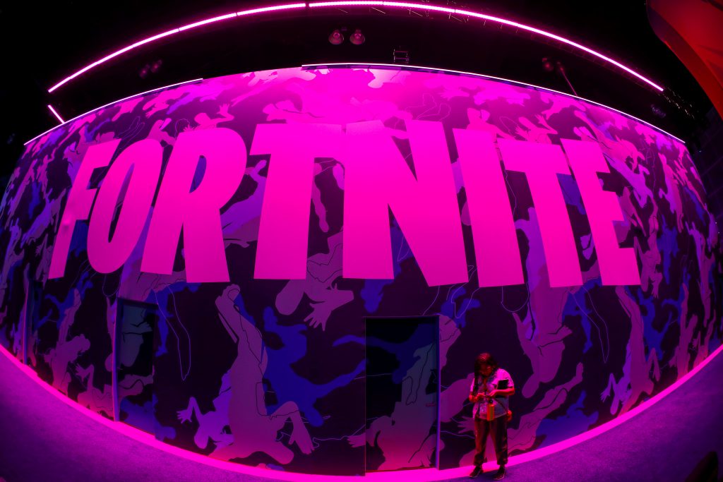 FILE PHOTO: An attendee stops to text next to Epic Games Fortnite sign at E3, the annual video games expo revealing the latest in gaming software and hardware in Los Angeles