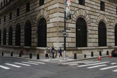 FILE PHOTO: People walk wearing masks outside The Federal Reserve Bank of New York in New York