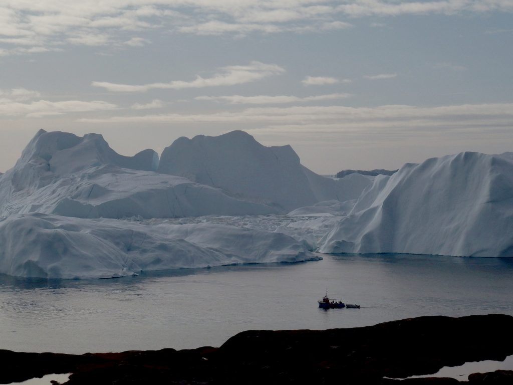 A fishing vessel sails in the ice fjord near Ilulissat