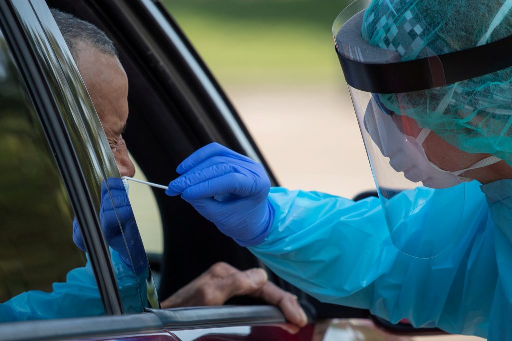 FILE PHOTO: Health care worker uses a swab to test man at COVID-19 drive in testing location in Houston, Texas