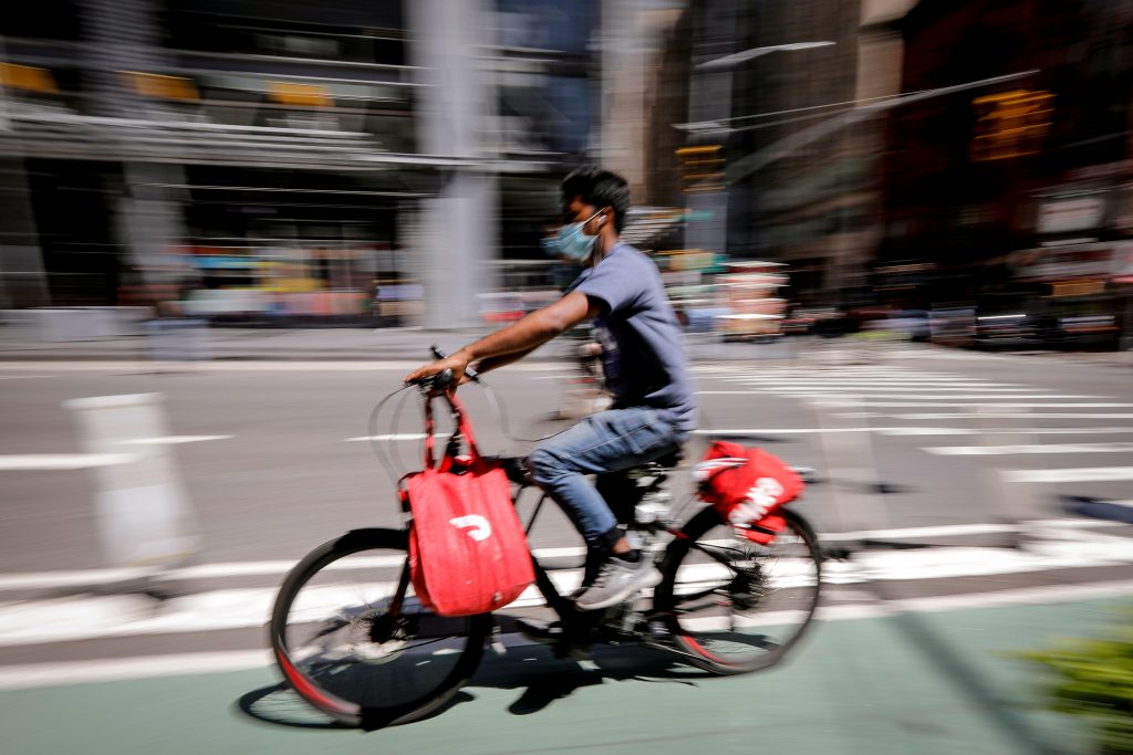 FILE PHOTO: A rider for “Grubhub” food delivery service rides a bicycle during a delivery in midtown Manhattan in New York