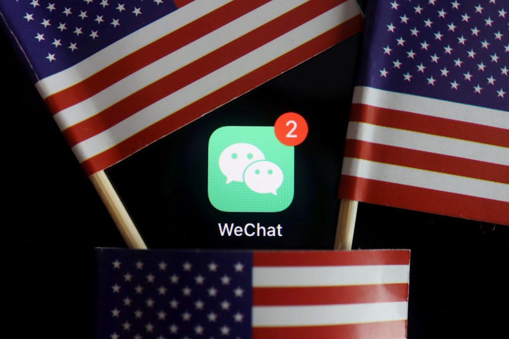 FILE PHOTO: The messenger app WeChat is seen among U.S. flags in this illustration picture
