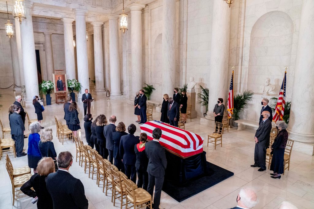 The flag-draped casket of Justice Ruth Bader Ginsburg is visible as Chief Justice of the United States John Roberts speaks during a private ceremony at the Supreme Court in Washington