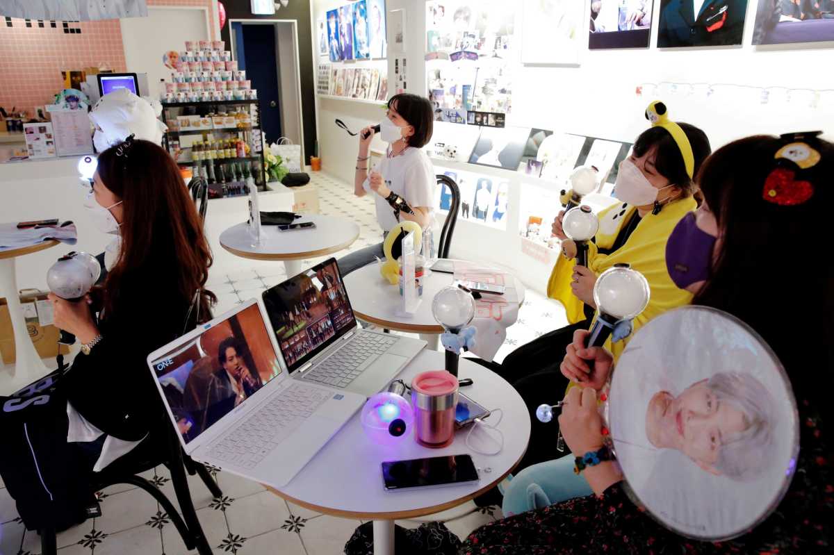 Fans of K-pop idol boy band BTS enjoy as they watch a live streaming online concert