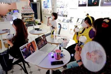 Fans of K-pop idol boy band BTS enjoy as they watch a live streaming online concert