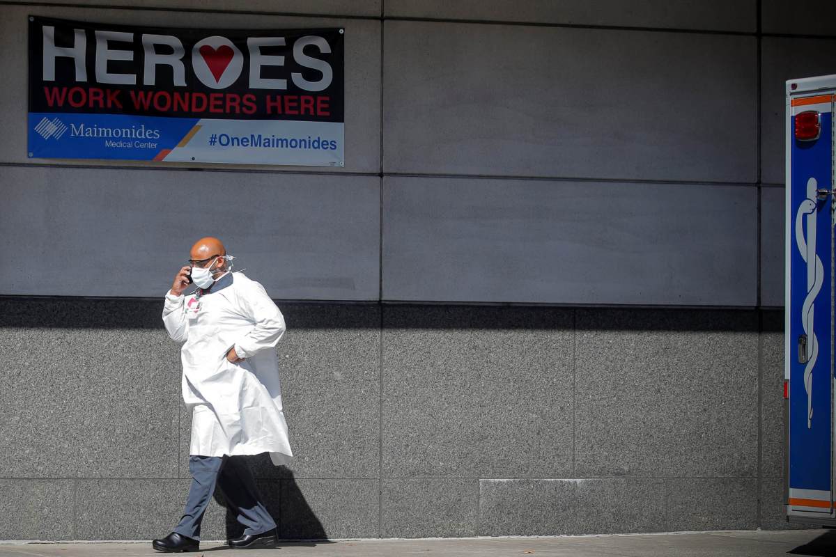 A doctor speaks on his phone outside the Emergency entrance to Maimonides Medical Center in the Borough Park neighborhood of Brooklyn, New York