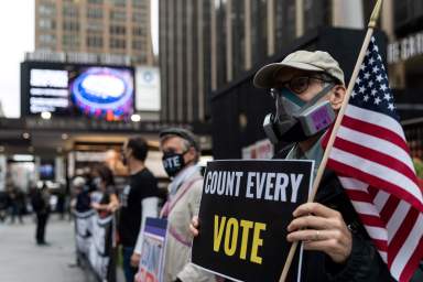 FILE PHOTO: Voters line up to cast ballots on the first day of early voting in New York