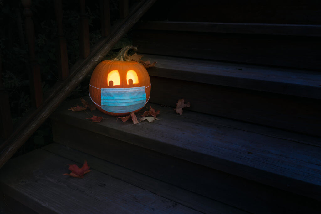 Lighted Halloween Jack o Lantern Pumpkin Wearing Covid PPE Mask On Steps At Night