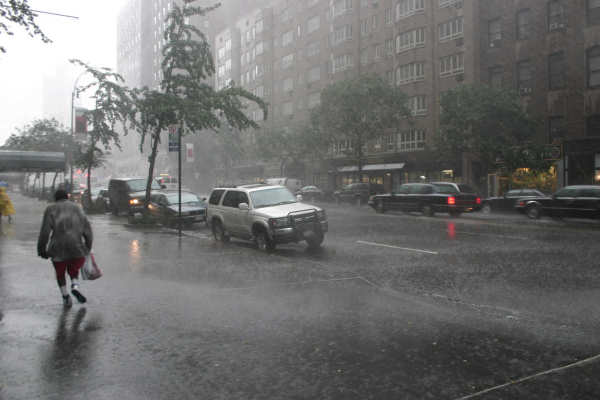 Road with cars in stormy weather people running