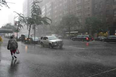 Road with cars in stormy weather people running