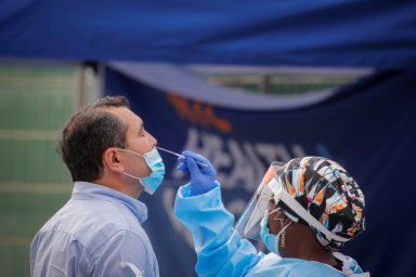A health worker takes a swab sample from a man to test for the coronavirus disease (COVID-19) in the Borough Park in Brooklyn, New York