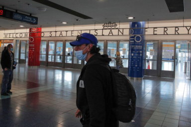 A man wears a mask as he walks through the Staten Island Ferry Terminal in Staten Island, New York