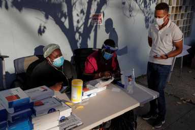 A man speaks to healthcare workers before taking a test for the coronavirus disease (COVID-19) in Staten Island, New York