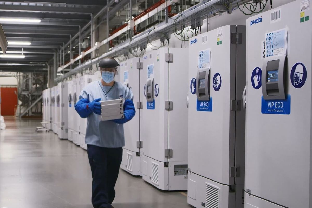A worker passes a line of freezers holding coronavirus disease (COVID-19) vaccine candidate BNT162b2 at a Pfizer facility in Puurs
