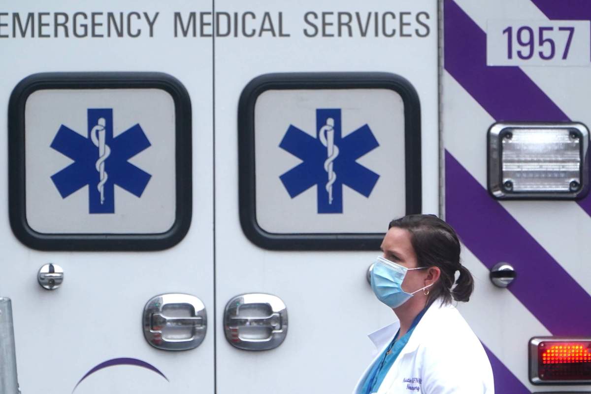 A health care professional walks past an ambulance during the coronavirus disease (COVID-19) pandemic in the Manhattan borough of New York City