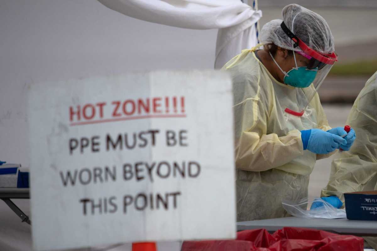 FILE PHOTO: A healthcare worker prepares specimen collection tubes at a coronavirus disease (COVID-19) drive-thru testing location in Houston