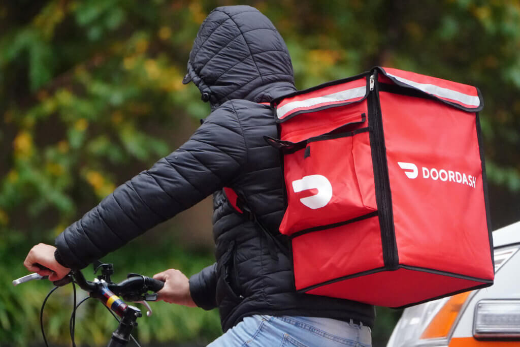FILE PHOTO: A delivery person for Doordash rides his bike in the rain in the Manhattan borough of New York City