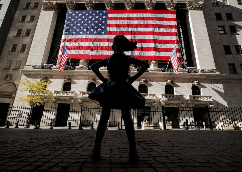 FILE PHOTO: The Fearless Girl statue is seen as the  U.S. flag covers the front facade of the NYSE in New York
