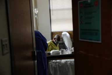 Andre Johnson, a coronavirus disease (COVID-19) positive patient, sits in his isolation room at Roseland Community Hospital on the South Side of Chicago, Illinois