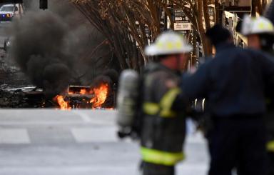A vehicle burns near the site of an explosion in the area of Second and Commerce in Nashville