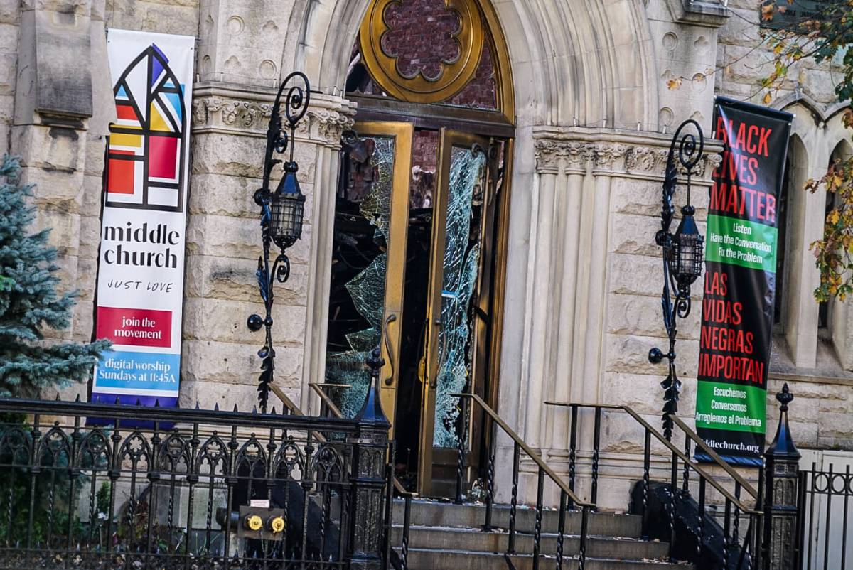 Middle Collegiate Church’s brass doors hang on their hinges with broken glass