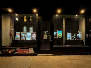 Lighting the darkness, digital images are bright in the windows of W. 8th St.