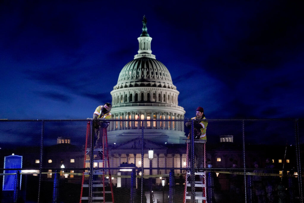FILE PHOTO: Workers install heavy-duty security fencing around the U.S. Capitol a day after supporters of U.S. President Donald Trump stormed the Capito