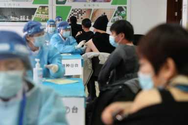 Medical workers administer COVID-19 vaccine at a makeshift vaccination site in Beijing