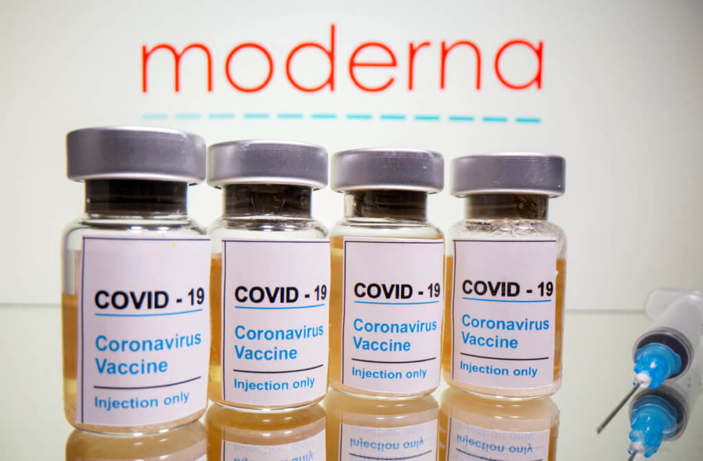 FILE PHOTO: Vials and medical syringe are seen in front of Moderna logo in this illustration