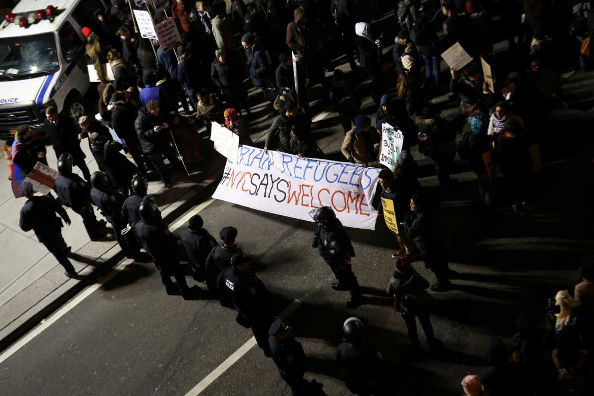 FILE PHOTO: Protesters gather with a sign that reads “Syrian refugees: NYC says welcome” outside Terminal 4 at JFK airport in opposition to U.S. President Donald Trump’s proposed ban on immigration in Queens, New York City