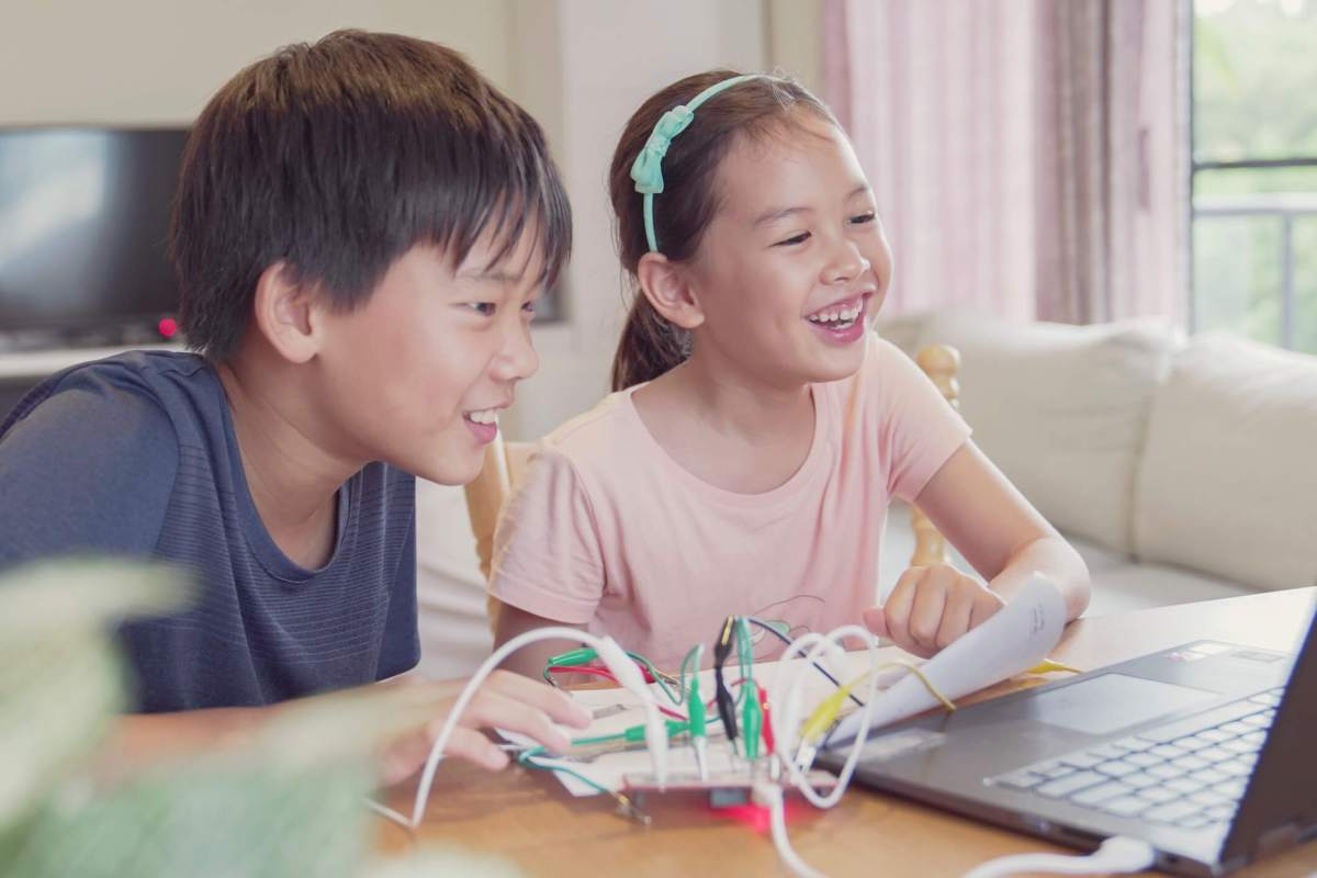Mixed race young Asian children having fun learning coding together, learning remotely at home, STEM science, homeschooling education, Social distancing, isolation concept