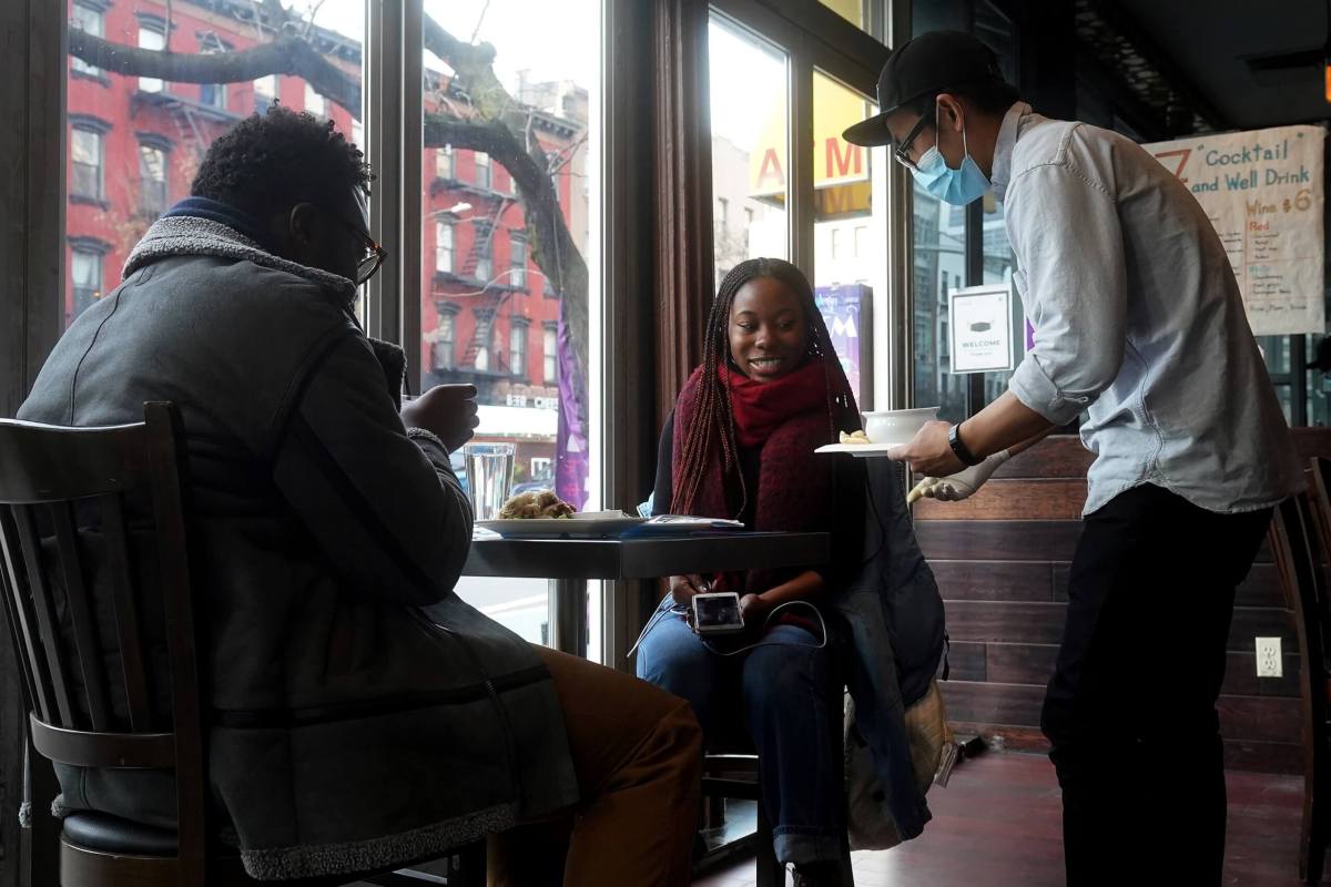 A server brings food to a table in a restaurant in the Manhattan borough of New York City