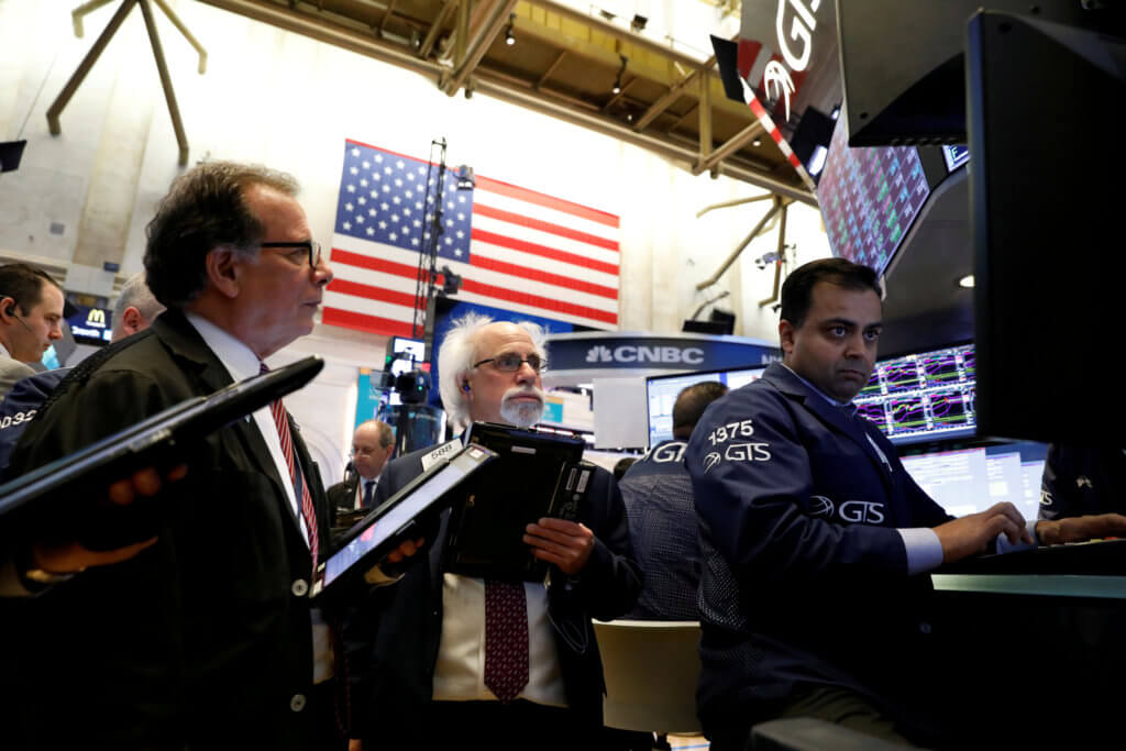 FILE PHOTO: Traders work on the floor of the New York Stock Exchange, (NYSE) in New York