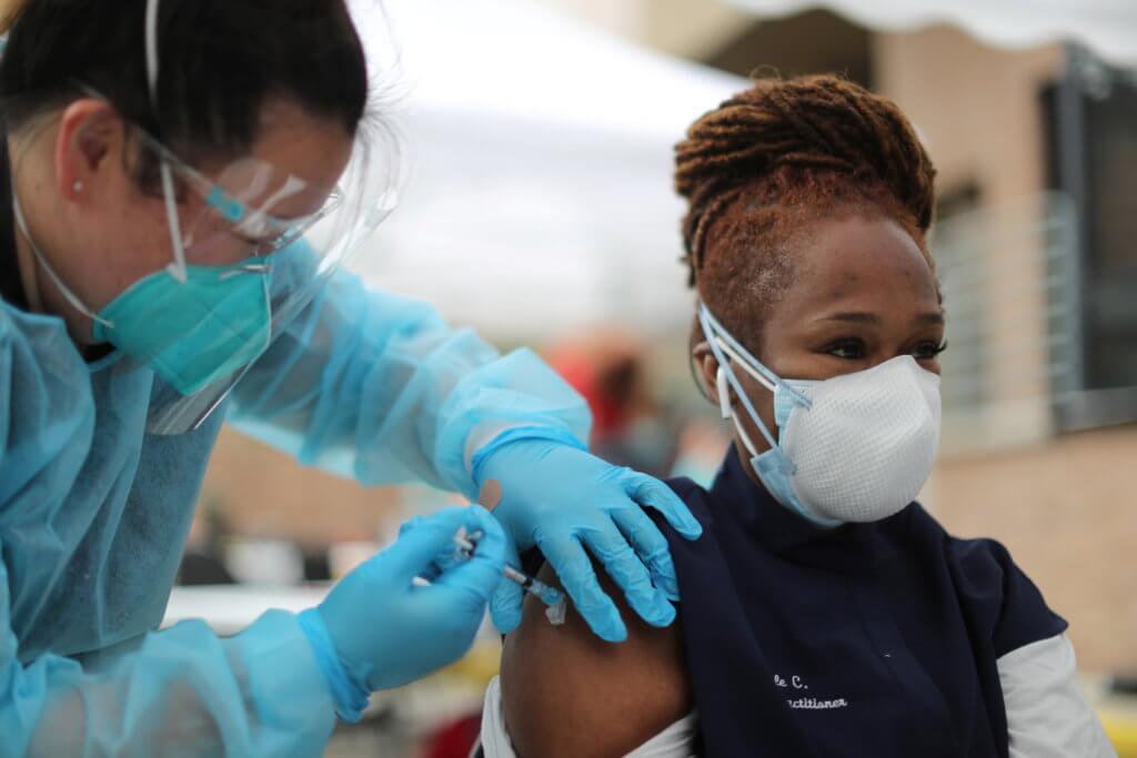 FILE PHOTO: Nurse practitioner Nicole Monk, 44, receives a coronavirus disease (COVID-19) vaccination at the LA Mission homeless shelter on Skid Row, in Los Angeles
