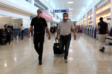 U.S. Senator Ted Cruz (R-TX) walks along an unidentified person at the Cancun International Airport before boarding his plane back to the U.S., in Cancun