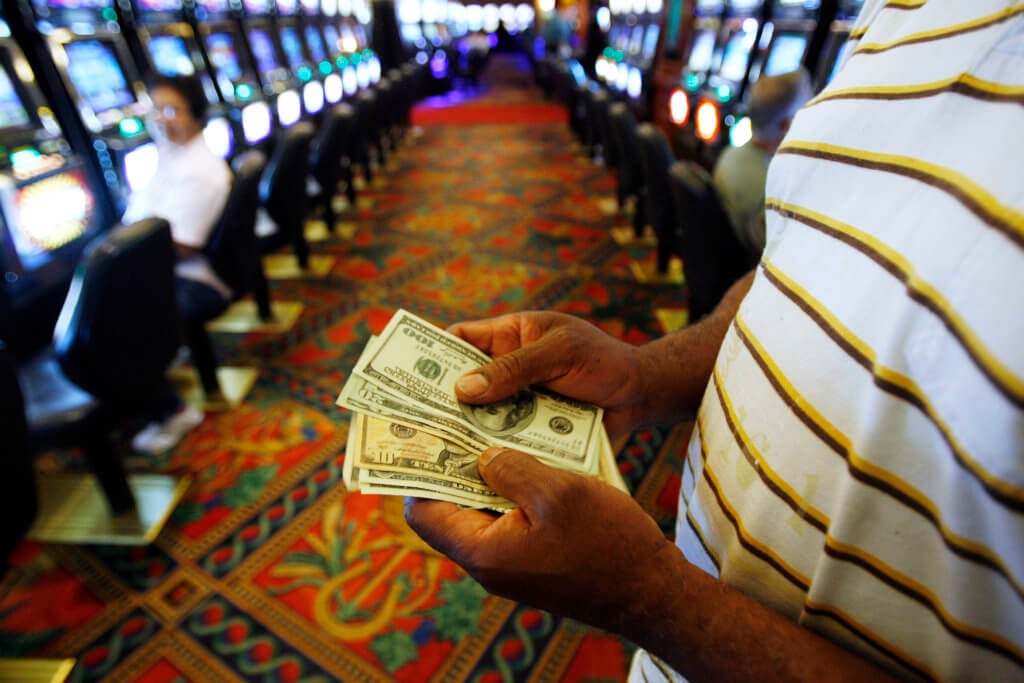 A man counts money after winning while playing the slot machines at the Empire City Casino in Yonkers, New York