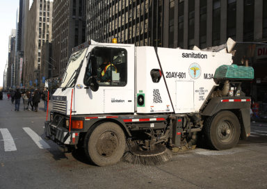 A sanitation truck cleans up 6th Ave after the Macy’s Thanksgiving Day Parade in New York