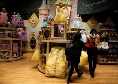FILE PHOTO: Customers look at “Beauty and the Beast” merchandise in a Disney Store in New York