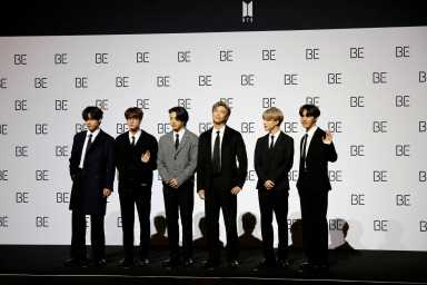FILE PHOTO: Members of K-pop boy band BTS pose for photographs during a news conference promoting their new album “BE(Deluxe Edition)” in Seoul